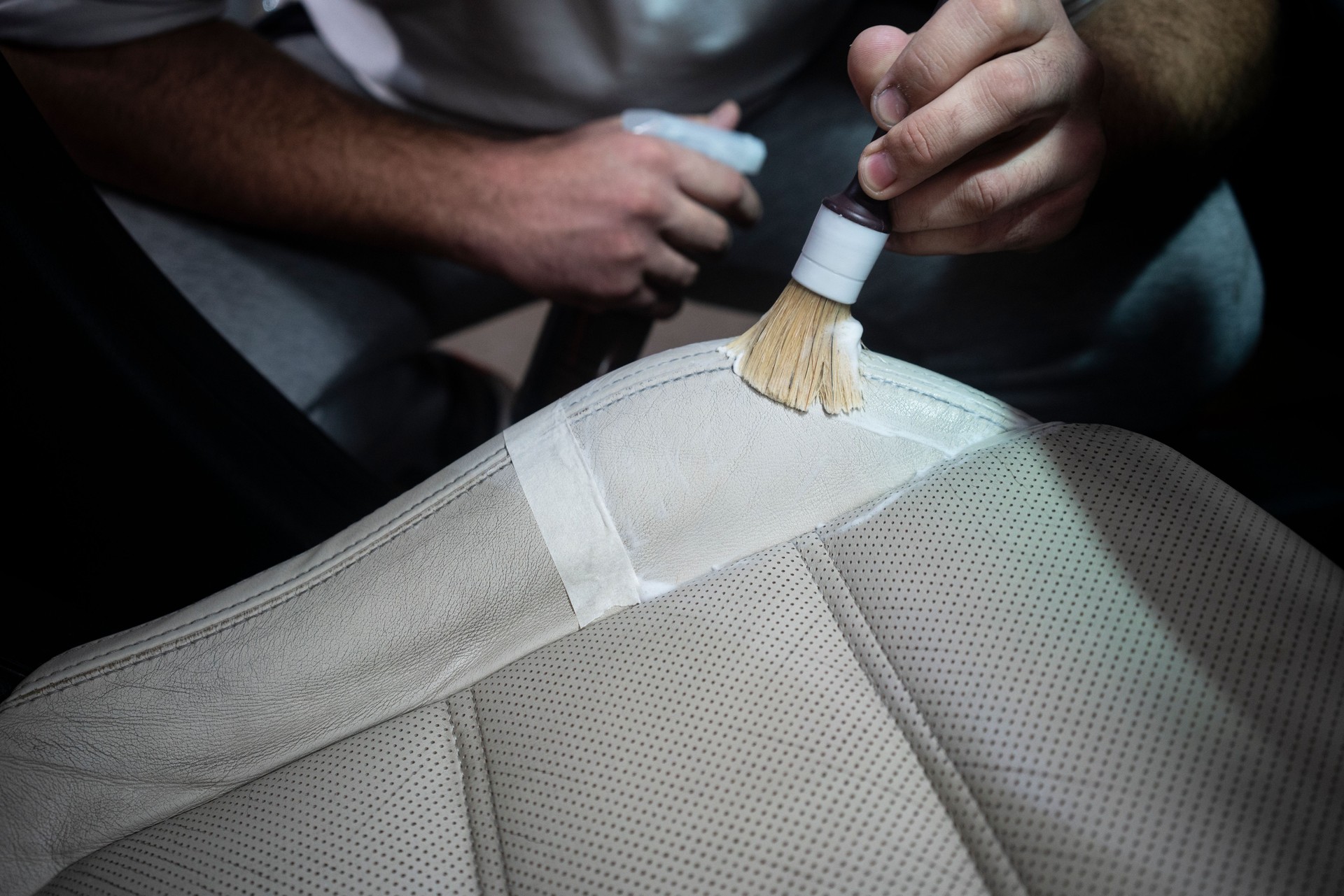 Man cleaning leather car seat